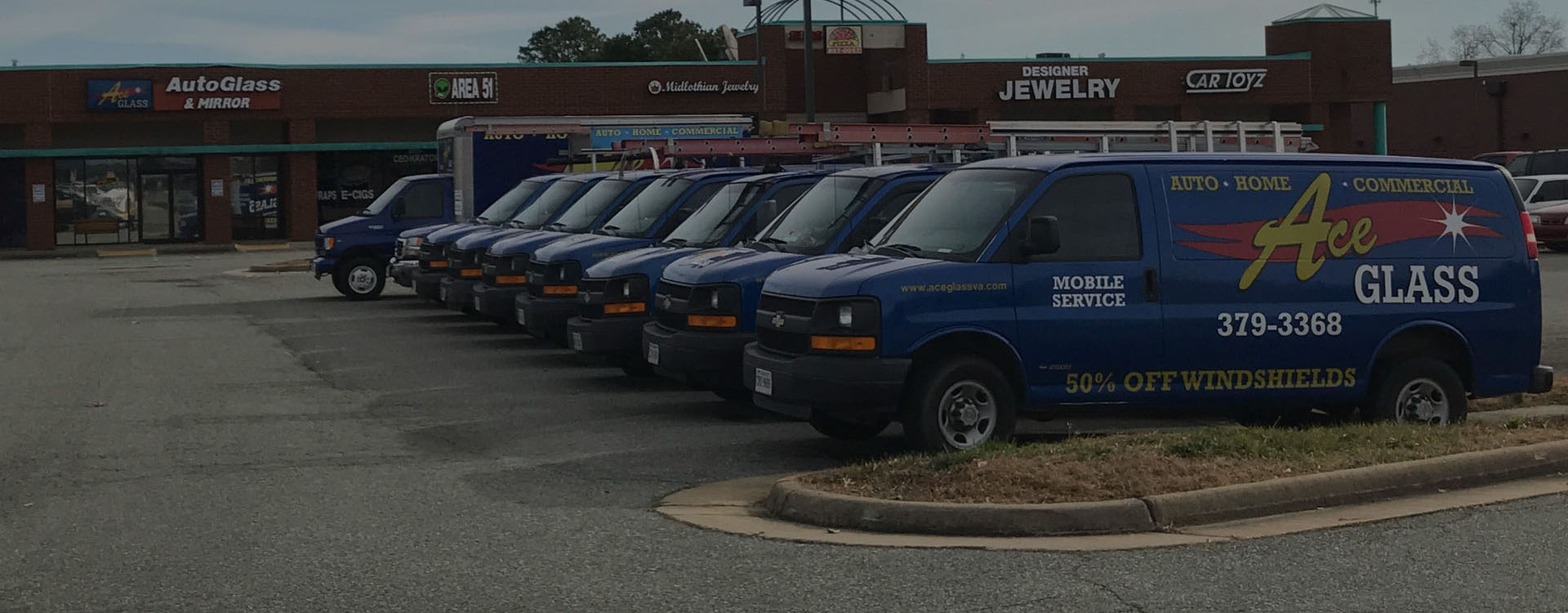 Row of Ace Glass service vans parked outside the Richmond shop