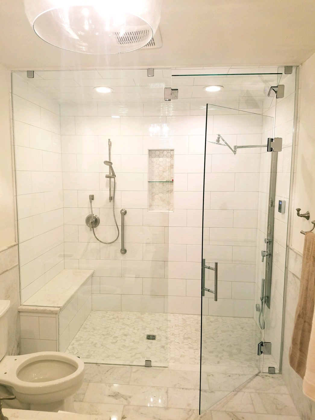 Frameless glass shower enclosure in a tiled bathroom
