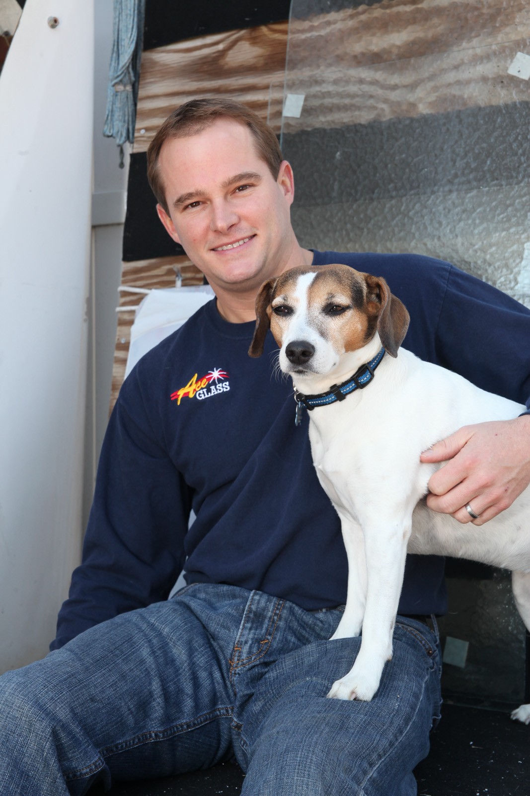 Ace Glass team member holding the shop's beagle